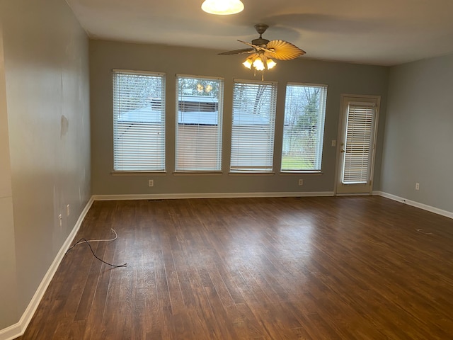 spare room with ceiling fan and dark wood-type flooring