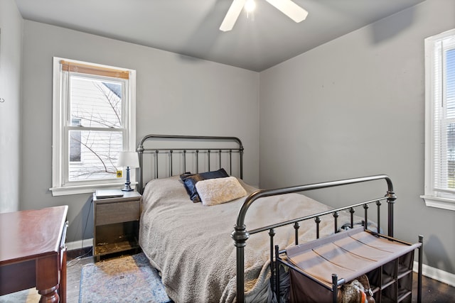 bedroom with multiple windows, ceiling fan, and wood-type flooring