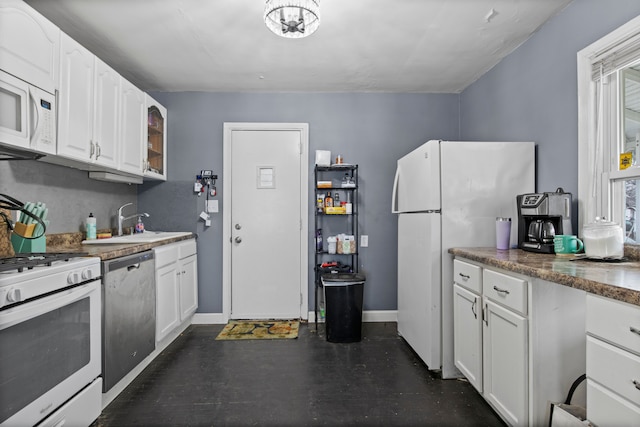 kitchen featuring sink, white cabinets, a healthy amount of sunlight, and white appliances