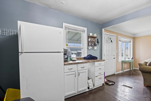 kitchen featuring white cabinetry, white fridge, and dark wood-type flooring