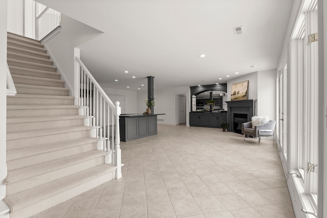 stairs with tile patterned floors, a fireplace, and a healthy amount of sunlight