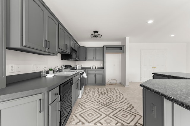 kitchen featuring black appliances, gray cabinetry, light tile patterned floors, and sink