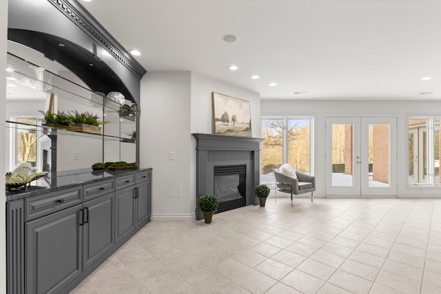 living room featuring light tile patterned floors, french doors, and a healthy amount of sunlight