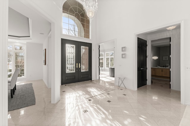 entrance foyer with french doors, a high ceiling, and an inviting chandelier