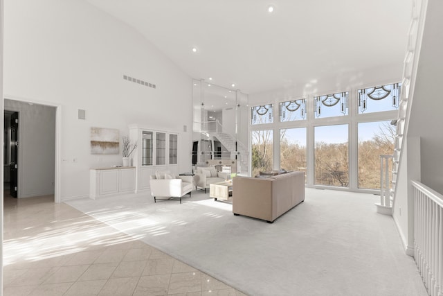 unfurnished living room featuring light carpet and high vaulted ceiling