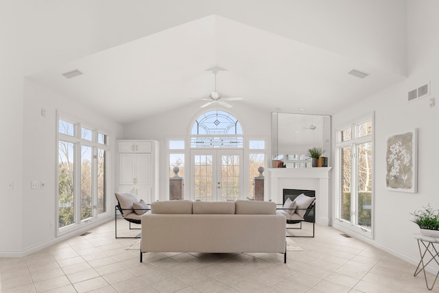 living room featuring ceiling fan, french doors, light tile patterned floors, and vaulted ceiling