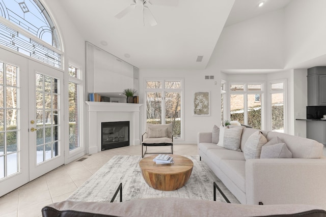 living room featuring ceiling fan, plenty of natural light, high vaulted ceiling, and light tile patterned floors