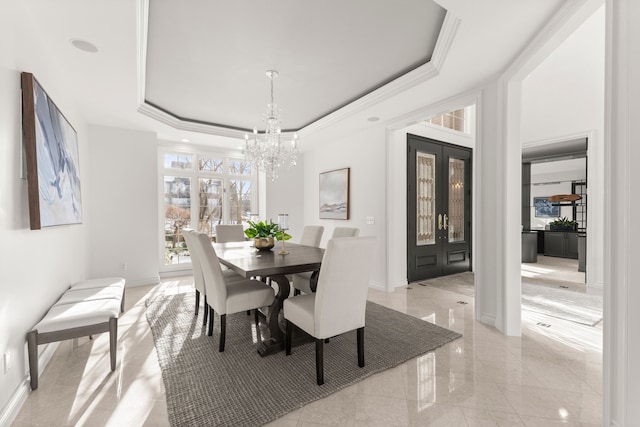 dining space featuring a notable chandelier, french doors, crown molding, and a tray ceiling