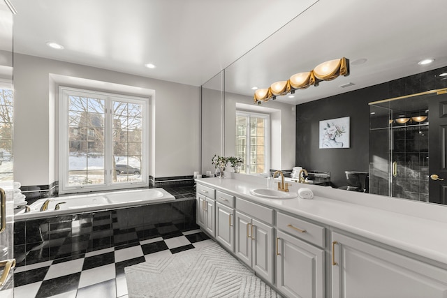 bathroom featuring vanity and tiled bath