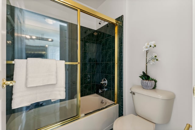 bathroom featuring combined bath / shower with glass door and toilet