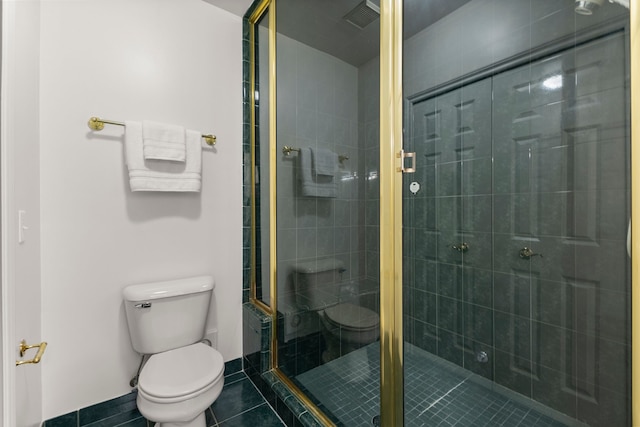 bathroom with tile patterned floors, toilet, and a shower with shower door