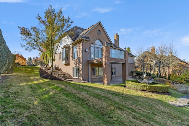 rear view of property with a lawn