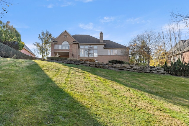 rear view of property featuring a lawn