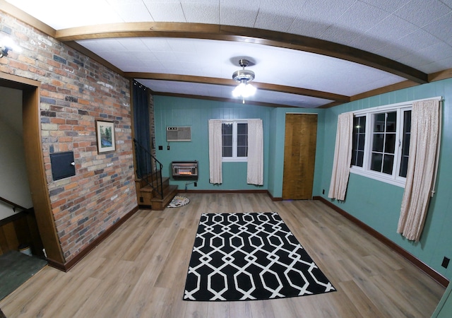 interior space featuring brick wall, wood-type flooring, beam ceiling, and heating unit