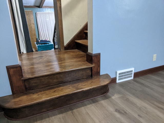 staircase with hardwood / wood-style floors