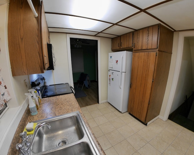 kitchen featuring electric stove, ceiling fan, sink, and white fridge