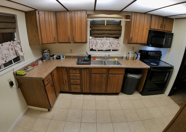 kitchen with sink, light tile patterned floors, and black appliances