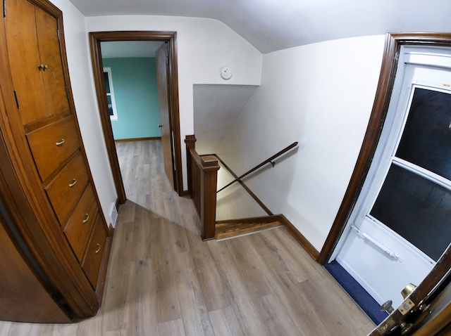 stairway featuring vaulted ceiling and hardwood / wood-style floors