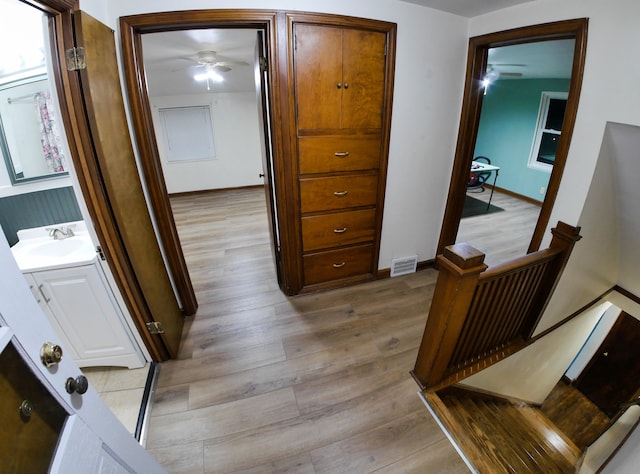 hallway with sink and light hardwood / wood-style floors