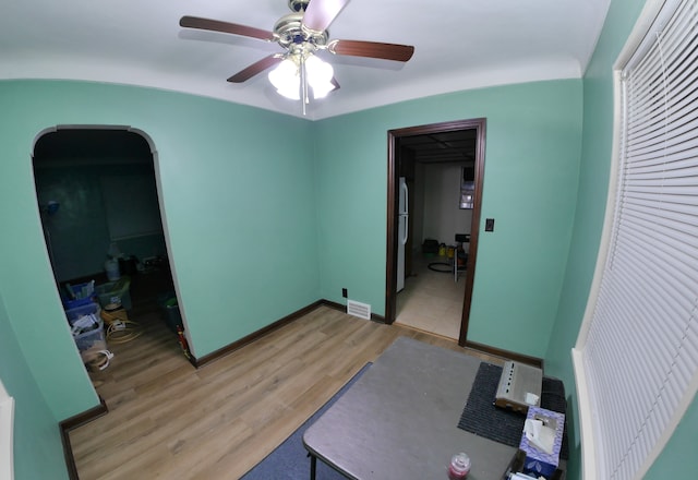 bedroom with ceiling fan, fridge, and light hardwood / wood-style floors