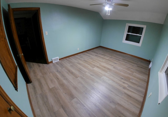 empty room featuring ceiling fan, lofted ceiling, and light wood-type flooring