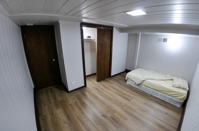 bedroom featuring wood ceiling, light hardwood / wood-style floors, and a closet