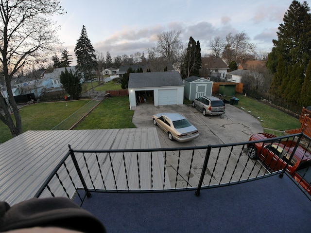 exterior space featuring a garage, a yard, and a storage unit