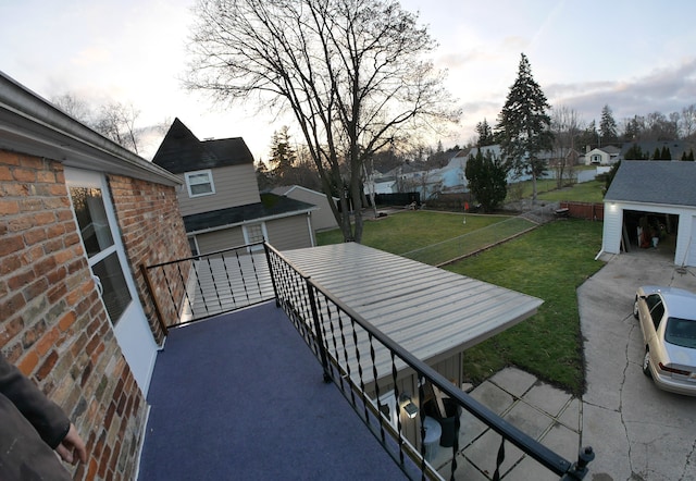 view of patio featuring a garage, an outdoor structure, and a balcony