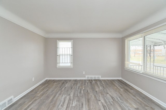 unfurnished room featuring light hardwood / wood-style flooring, a healthy amount of sunlight, and ornamental molding