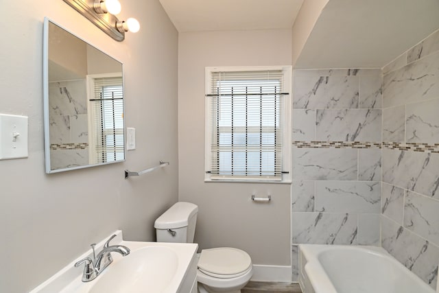 full bathroom with tiled shower / bath combo, toilet, and sink