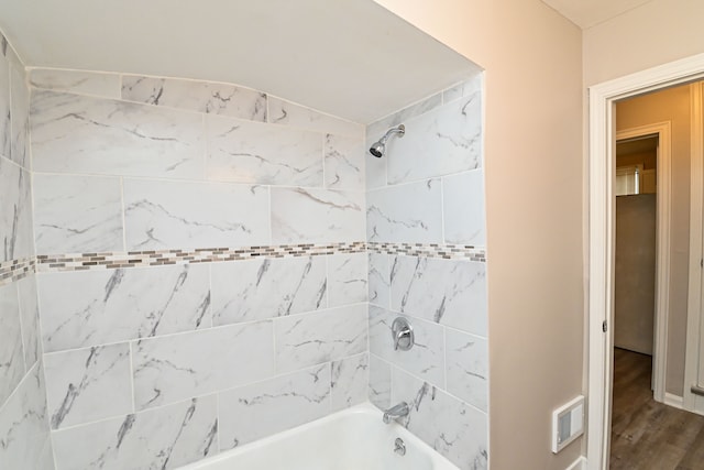 bathroom with wood-type flooring and tiled shower / bath combo