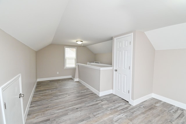 bonus room with light hardwood / wood-style floors and lofted ceiling