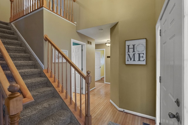 stairway featuring hardwood / wood-style flooring and a high ceiling