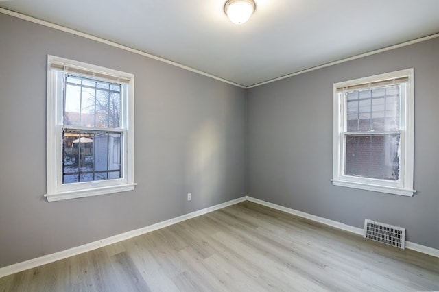 spare room with light hardwood / wood-style flooring and ornamental molding