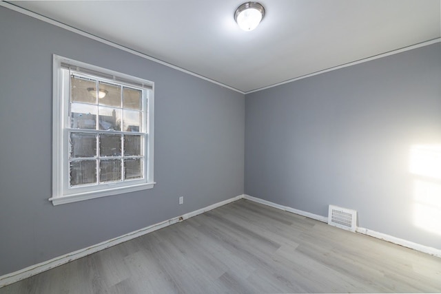 unfurnished room with light hardwood / wood-style floors and crown molding