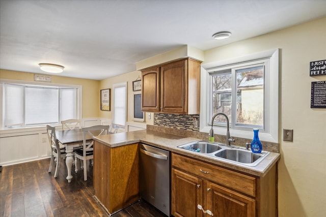 kitchen featuring dishwasher, sink, dark hardwood / wood-style flooring, backsplash, and kitchen peninsula