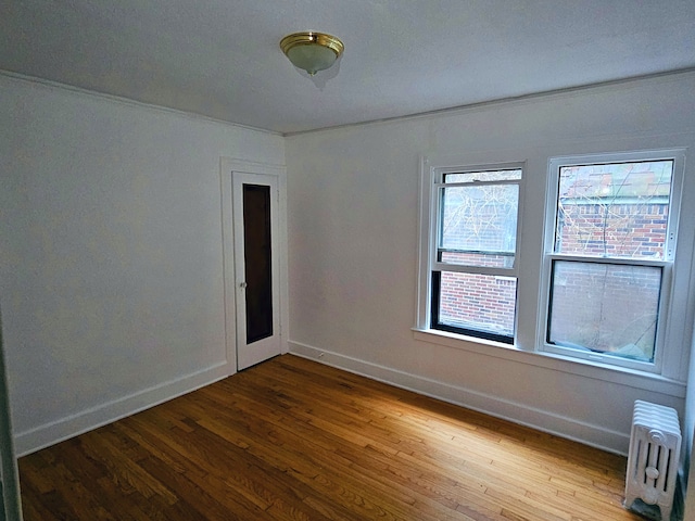 empty room with radiator and wood-type flooring