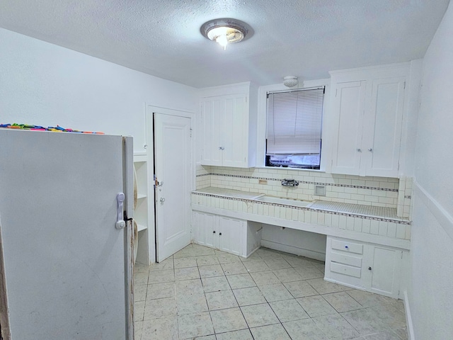 bathroom featuring backsplash, sink, and a textured ceiling