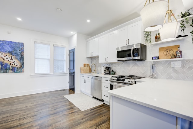 kitchen featuring pendant lighting, white cabinetry, dark wood-type flooring, and appliances with stainless steel finishes