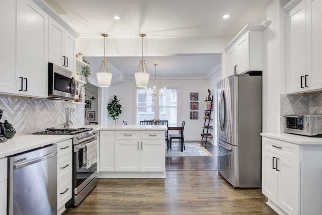 kitchen with white cabinetry, pendant lighting, stainless steel appliances, and dark hardwood / wood-style floors