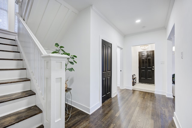 entrance foyer with ornamental molding and dark wood-type flooring