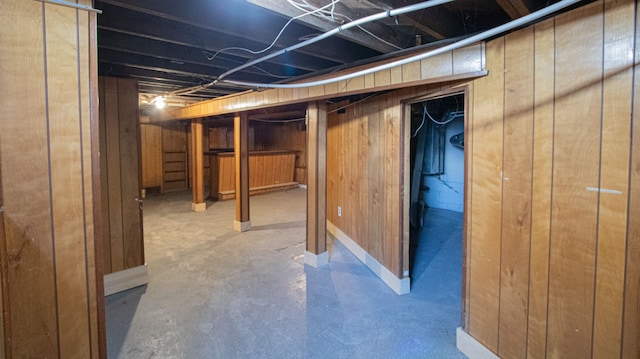 basement featuring wood walls