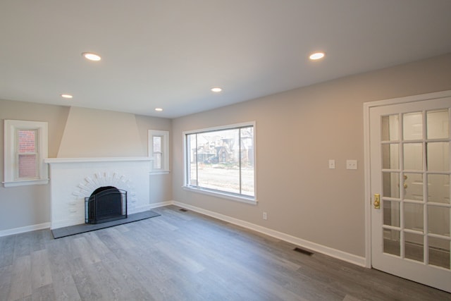 unfurnished living room featuring a fireplace and wood-type flooring