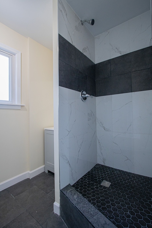 bathroom with a tile shower and tile patterned floors