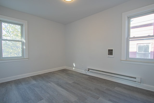 unfurnished room featuring dark hardwood / wood-style flooring and a baseboard radiator