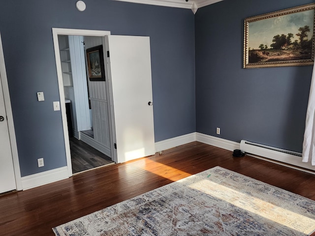 empty room featuring a baseboard heating unit, dark hardwood / wood-style floors, and ornamental molding