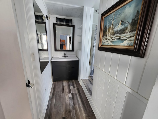 bathroom with vanity, hardwood / wood-style flooring, and wooden walls