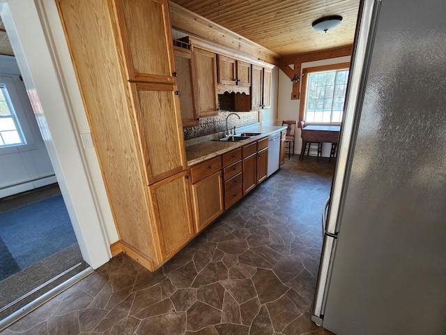 kitchen with dishwasher, backsplash, sink, wood ceiling, and stainless steel refrigerator