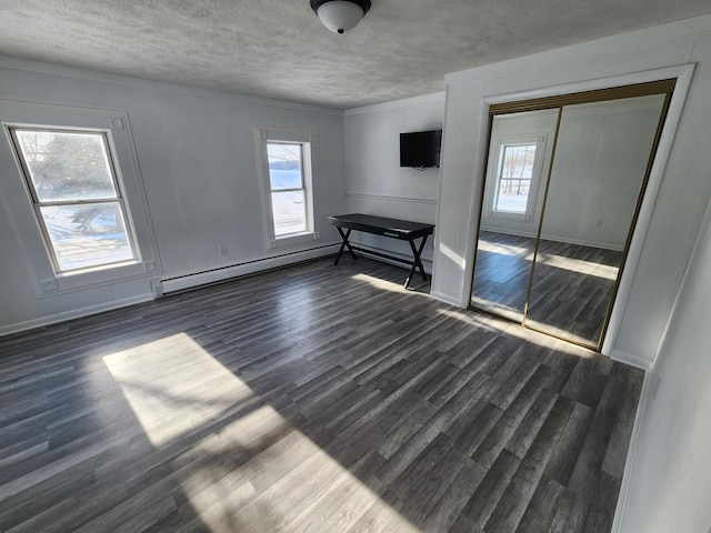 unfurnished living room with dark hardwood / wood-style flooring, plenty of natural light, and a textured ceiling