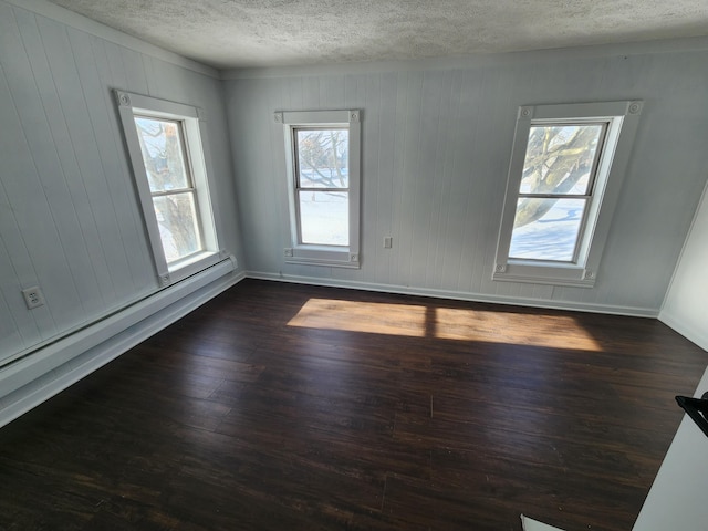 empty room featuring a wealth of natural light and dark wood-type flooring